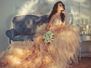 Beautiful lady in gorgeous couture dress on sofa