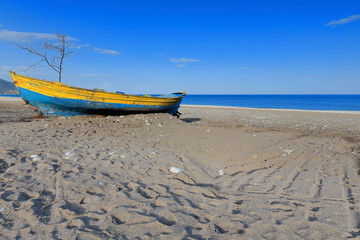 Old blue-yellow wooden boat stranded on the beach. Çirali-Turkey. 0358