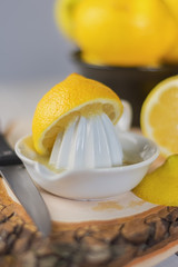 Juicer for lemon on wooden plank.