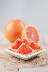 Slices of grapefruit on a wooden table.