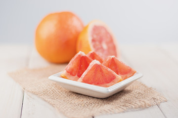 Slices of grapefruit on a wooden table.
