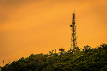 Silhouette telecommunications antenna for mobile phone at sunset