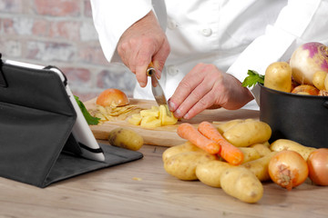 detail of hands of chef slicing potatoes
