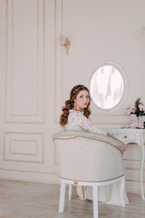 fashion studio photo of beautiful elegant bride with dark hair in luxurious wedding dress