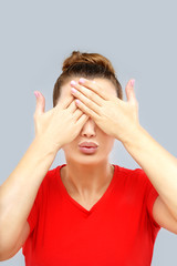 Portrait of young woman covering her face with hands.Kiss