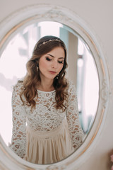 fashion studio photo of beautiful elegant bride with dark hair in luxurious wedding dress with headband