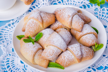 Mini croissants with dried apricots, figs and nuts on a plate