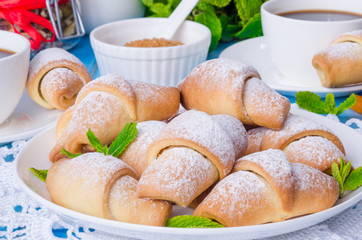 Mini croissants with dried apricots, figs and nuts on a plate
