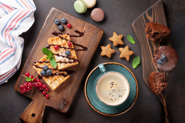 Coffee, sweets and waffles with berries