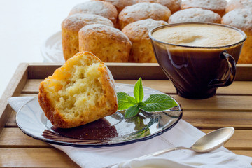 Muffins sprinkled with powdered sugar and cappuccino, daylight