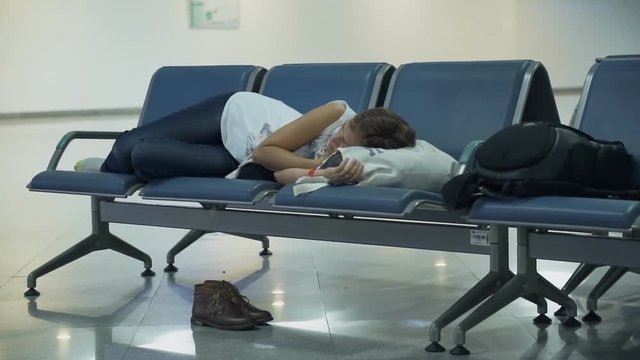 Attractive Woman Sleeping At The Airport Waiting Area.