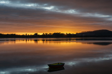 brilliant sunrise provides a glow and reflections across Tauranga harbor, New Zealand