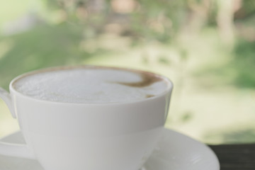 White cup of coffee on wood table