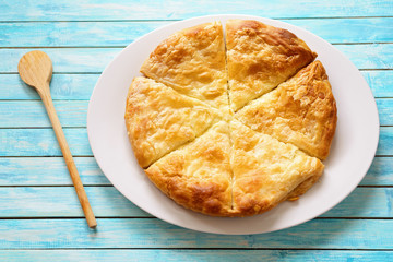 Greek cheese pie on a blue washed table