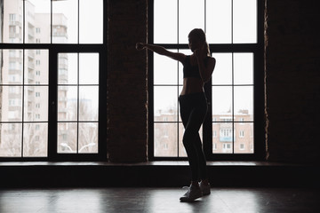 Fototapeta na wymiar Silhouette of woman athlete standing and doing shadow boxing exercises