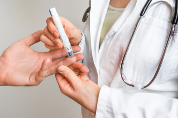 Measuring blood sugar on finger - diabetes concept