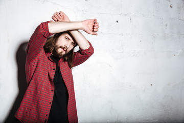 Serious young bearded hipster man looking at camera.