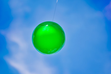 Big green ball was hanging under the eaves.
