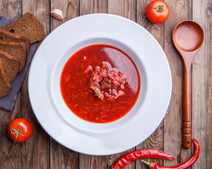 Beet soup in white plate with vegetables