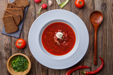 Beet soup in white plate with vegetables