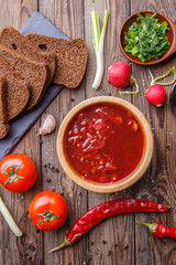 Beet soup in wooden plate with vegetables