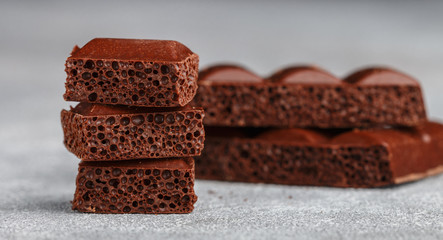 Porous milk chocolate, broken into pieces. Selective focus