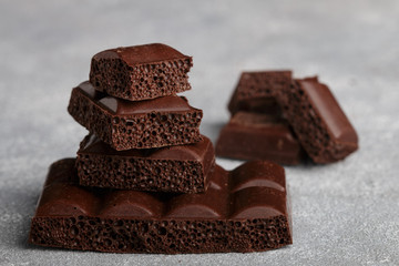 Porous milk chocolate, broken into pieces. Selective focus