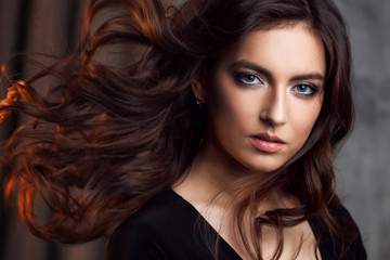 Delightful portrait of a woman brunettes, hair flying on the wind, sloppy styling