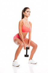 Full length portrait of a young fitness woman doing squatting