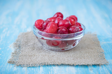 Frozen berries cherry on vintage wooden table.