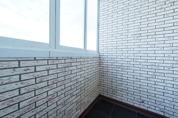 Interior balcony with floor tiles and decorative wall made of bricks