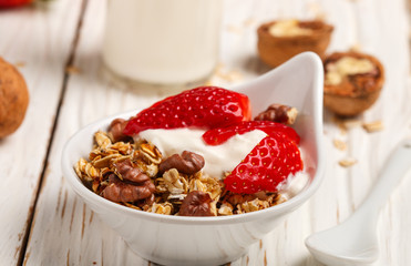 Homemade granola with fresh strawberries, yogurt and walnuts
