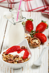 Homemade granola with fresh strawberries, yogurt and walnuts

