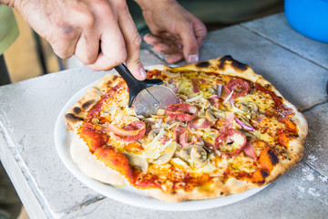 Cutting a slice of tasty pizza