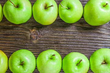 Ripe green apples on wooden background