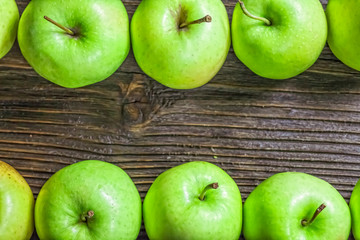 Ripe green apples on wooden background