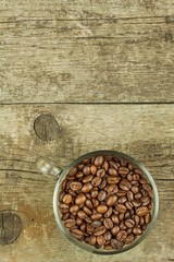 Cup of coffee beans on old wooden table. Sales of coffee. Decorations for the menu. Coffee shop.