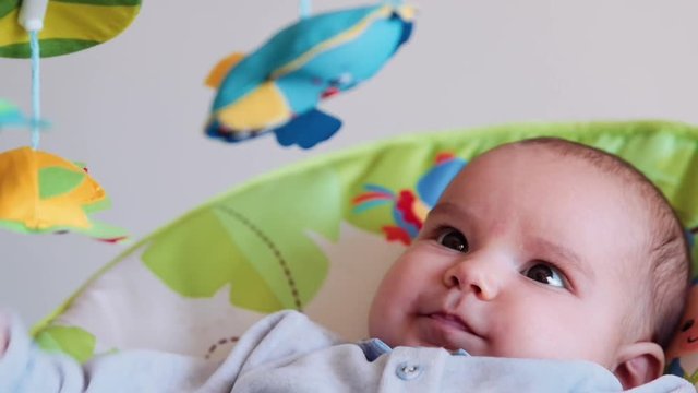 Little cute baby swinging and looking toys