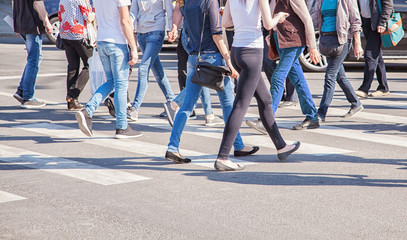 pedestrians walking on a crosswalk - obrazy, fototapety, plakaty