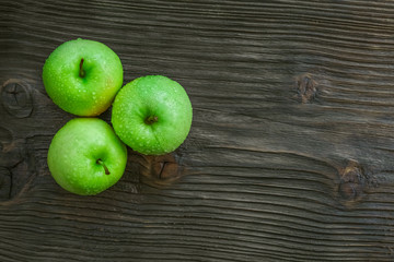 Ripe green apples on wooden background