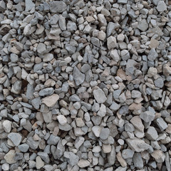 Abstract grey and beige gravel stone background, crushed gray stones and granite pieces texture, large detailed textured rough construction rock material mix pattern 