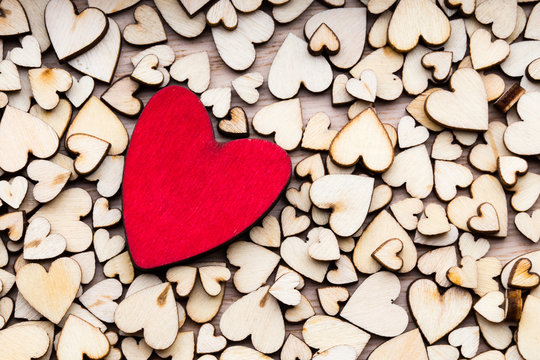 Wooden hearts, one red heart on the heart background.