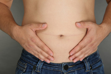 Man touching his fat belly, closeup