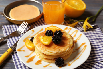 Stack of fresh pancakes with fruits on plate, closeup