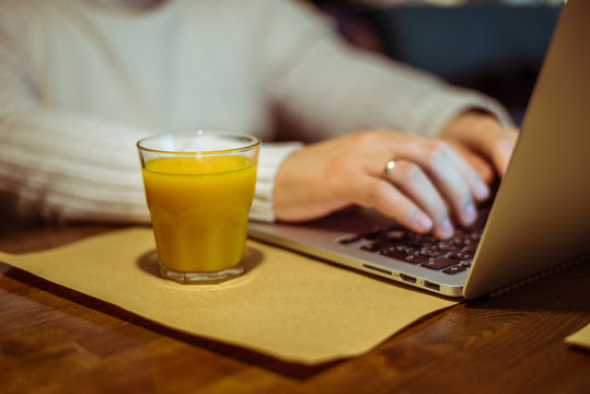 man drinks juse while working on laptop