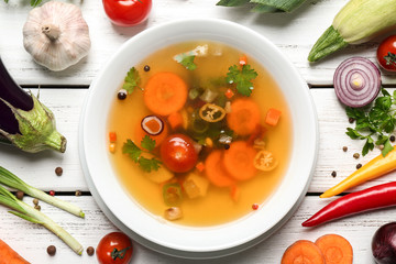 Soup and fresh vegetables on wooden background
