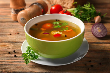 Bowl with fresh vegetable soup on wooden background