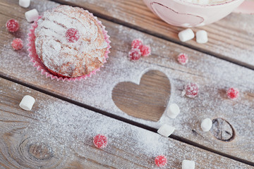 Tasty cupcake with berries and cup of coffee