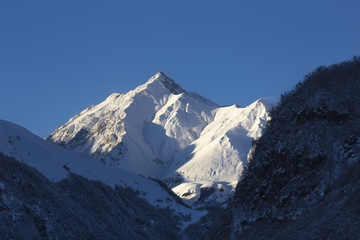 Mountain peak in snow glistens in the sun.