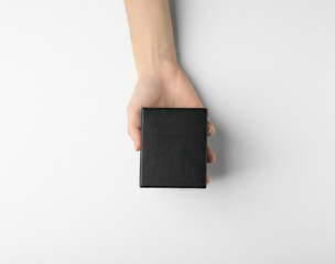 Female hand with black box on white background